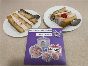 Zdjęcie_nr_10_przedstawia_urodzinową_kartkę_oraz_dwa_talerzyki_z_porcjami_tortu.png