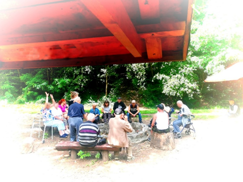 Zdjęcie_nr_17_przedstawia_mieszkańców_biesiadujących_wokół_paleniska.png