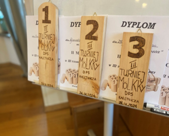 Zdjęcie_nr_3_przedstawia_puchary_i_dyplomy_dla_uczestników_III_Turnieju_Gry_w_Molkky.png