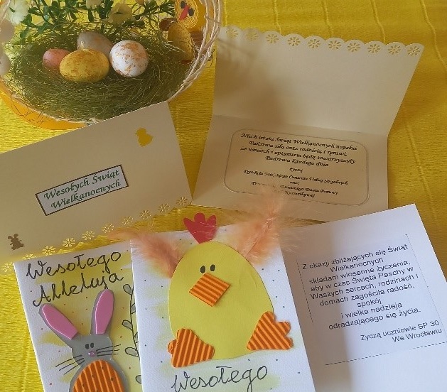 Pięć własnoręcznie wykonanych kartek Wielkanocnych z życzeniami. Jedna  z białego papieru z napisem Wesołego Alleluja, zajączkiem trzymającym pisankę i gałązkami bazi. Druga z napisem Wesołego Alleluja oraz kurczakiem wykonanym z kolorowego papieru i piórek. Pozostałe z życzeniami świątecznymi