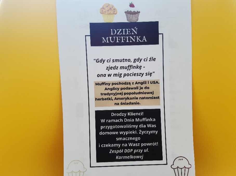 Na białej kartce z nadrukiem babeczek-muffinek , napis DZIEŃ MUFFINKA , informacja dotycząca pochodzenia muffinki oraz informacja dla klientów o przygotowanych z tej okazji wypiekach. Dodatkowo życzenia smacznego i szybkiego powrotu do Ośrodka
