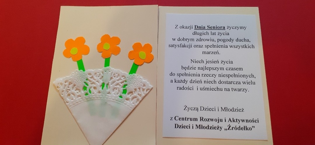 Na zdjęciu widać otwartą kartkę w kolorze czerwonym z wypisanymi życzeniami