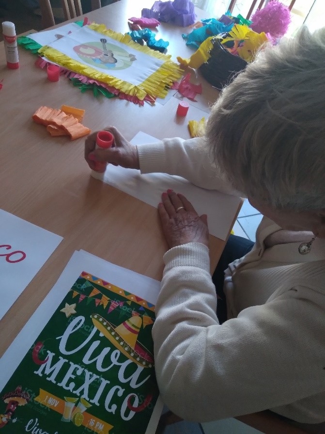 Na zdjęciach widać jak mieszkańcy przygotowują elementów piniaty podczas zajęć terapii zajęciowej.
