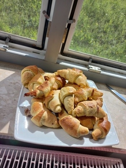  Zdjęcie nr.11 Widzimy na zdjęciu upieczone rogaliki umieszczone na białym talerzu.